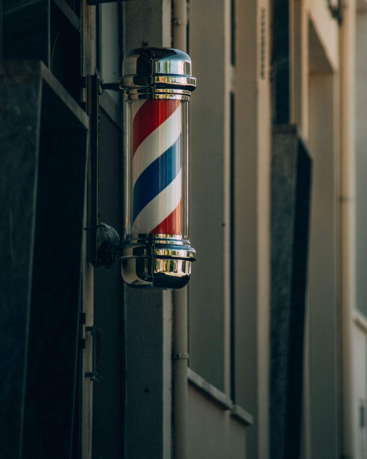 Poste de barbearia girando na fachada